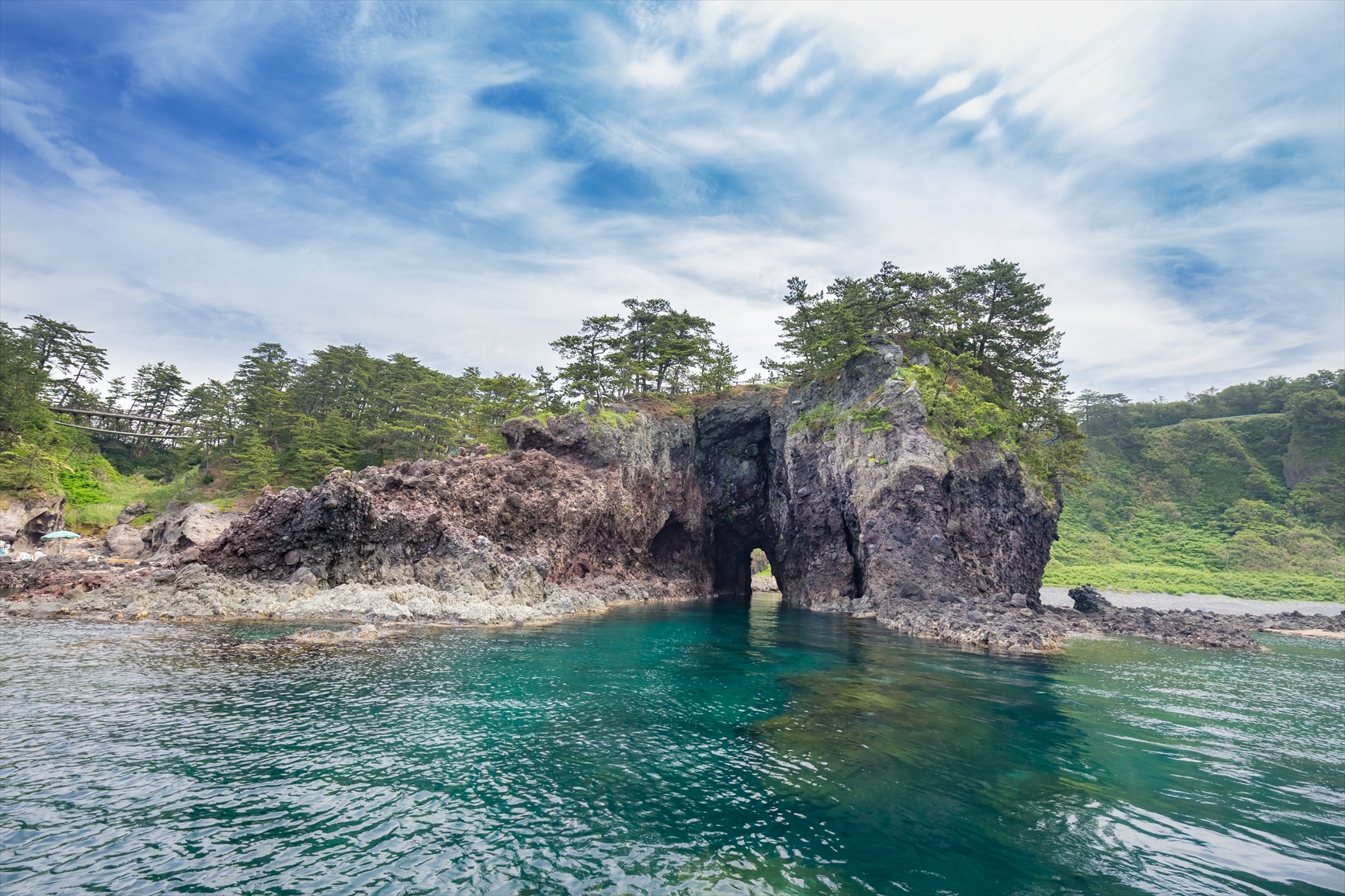 海上に２つの巌岩，男島、女島中央、左右，下部に流れる波の表現 能登半島の絶景・巌門（がんもん）の魅力と地震後の現在を知る
